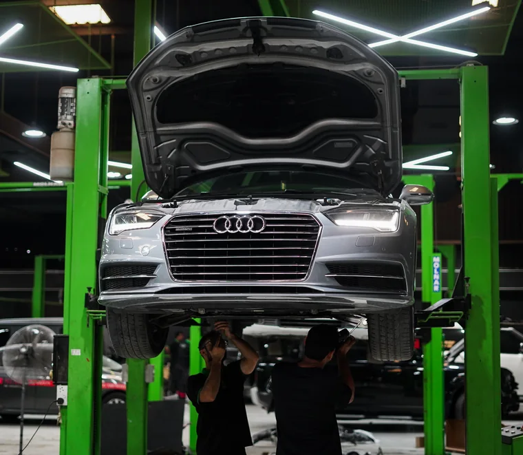 Audi A6 on a two-post lift for undercarriage service in Dubai