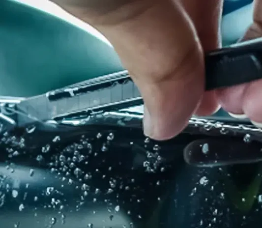 Close-up quality check of installed film at the System X Car Polish workshop in Dubai